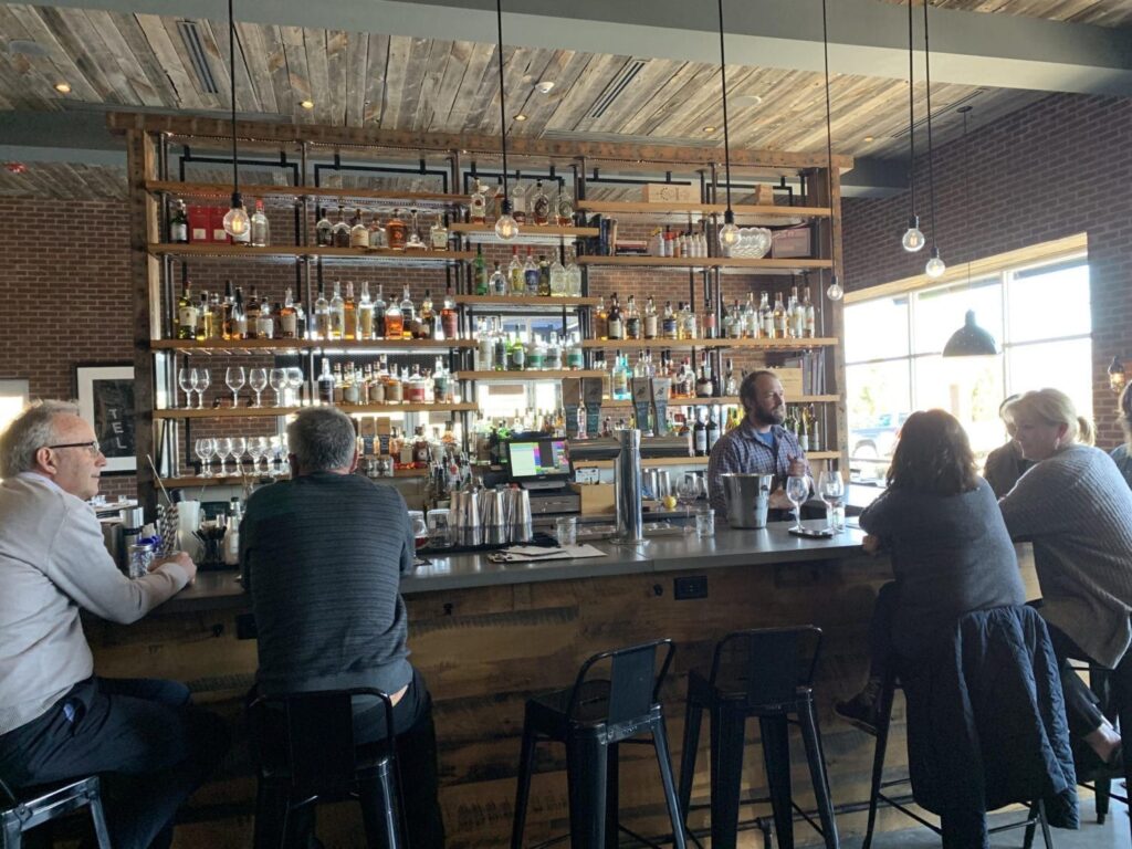 A group of people are sitting at a bar in a restaurant.