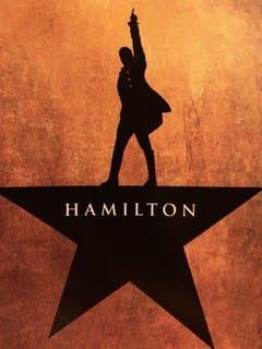 A silhouette of a man standing on top of a hamilton star.