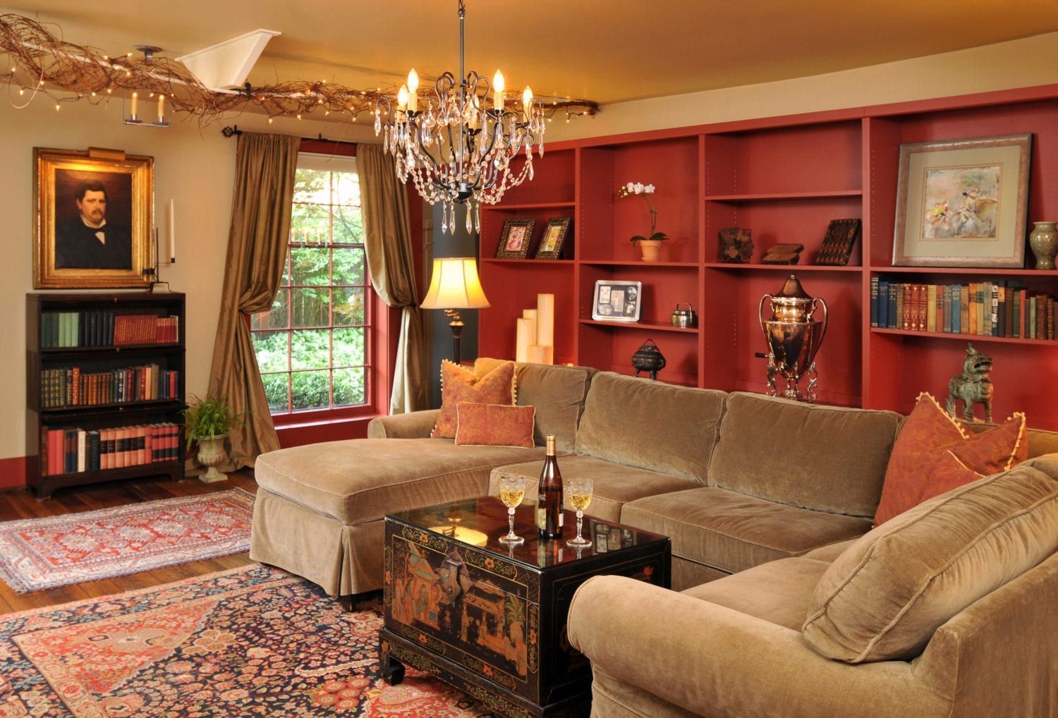 A living room with a sectional couch and a chandelier.