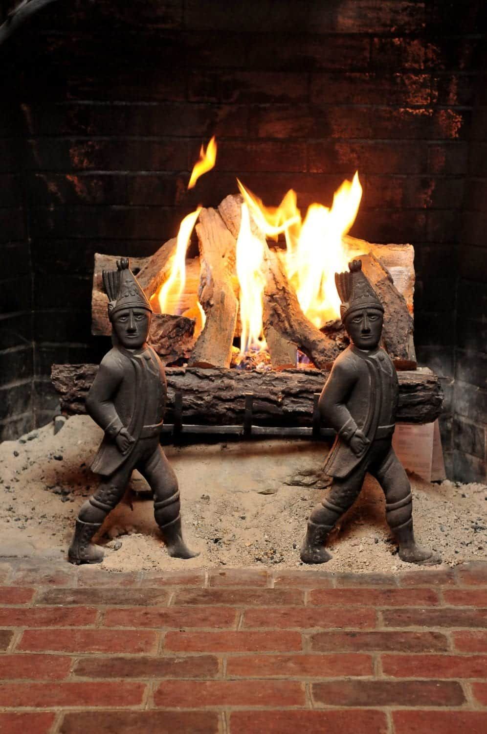 A fireplace with two statues in front of it.
