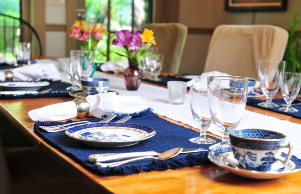 A table with plates , glasses , and a cup on it.