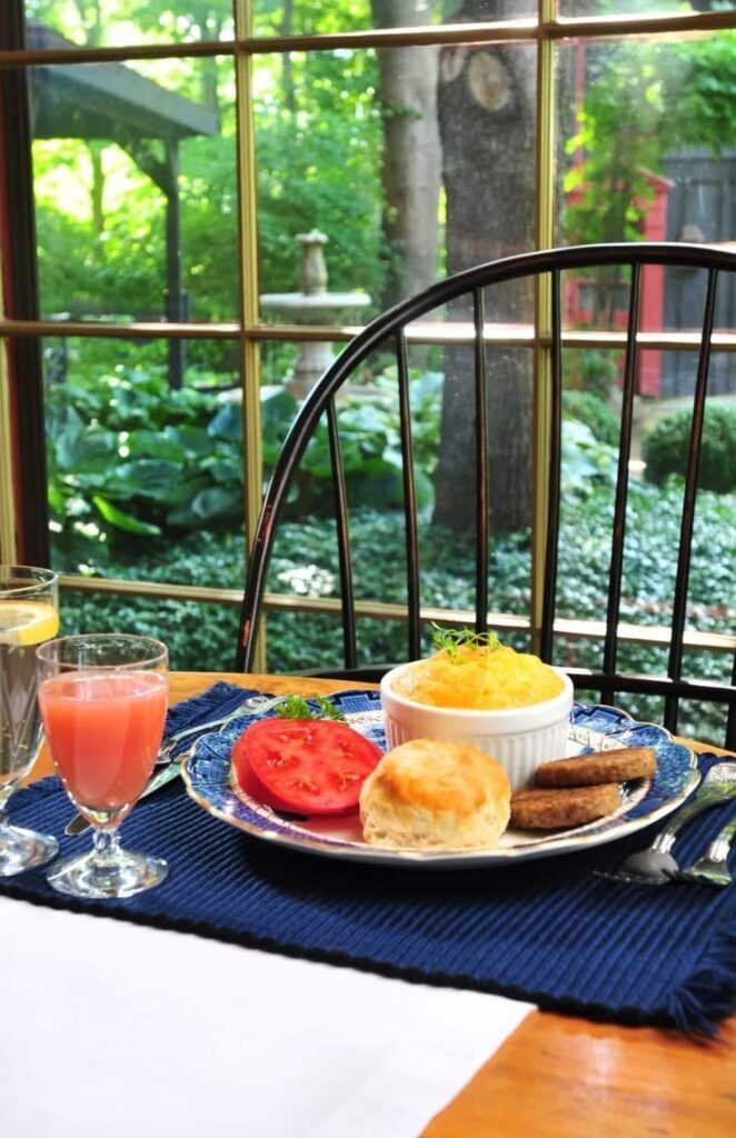 A plate of food is on a table in front of a window.