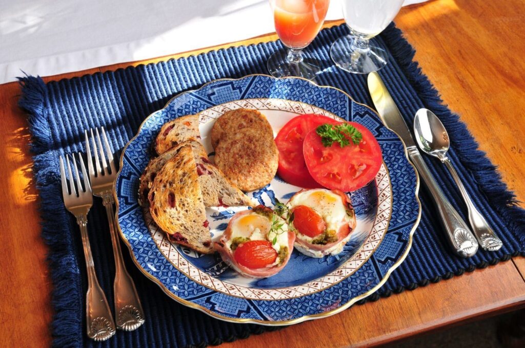 A plate of food with tomatoes and bread on a table.