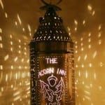 A lantern with a dragon on it is lit up in the dark.