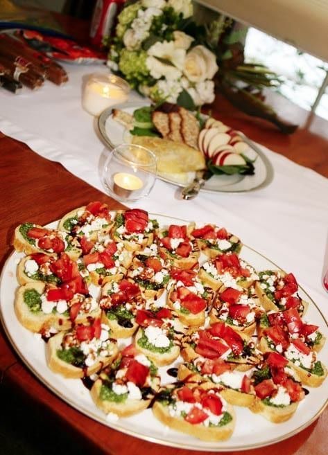 A plate of food on a table with a bouquet of flowers in the background.